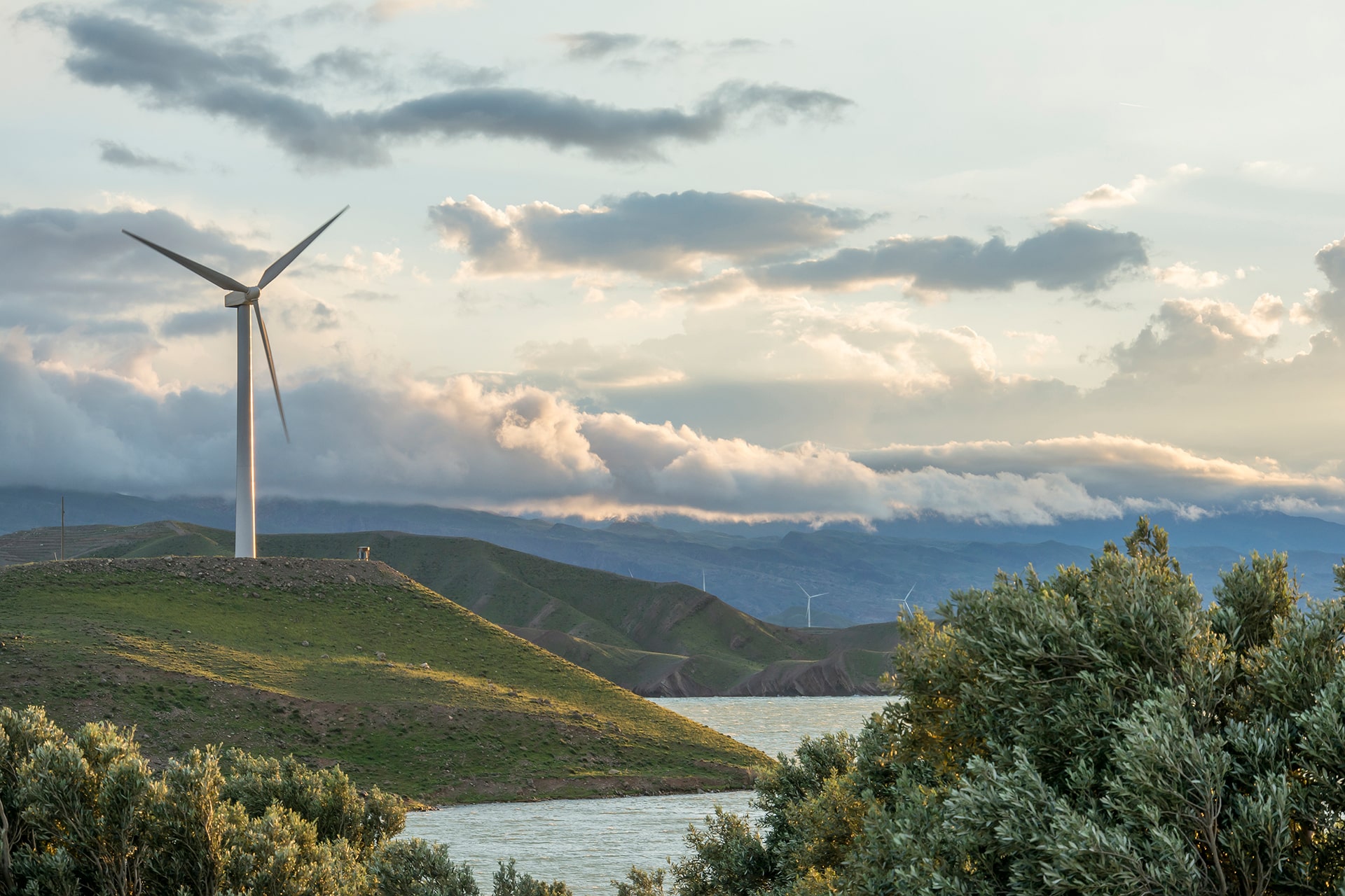 wind-power-turbine-hill-front-cloudy-sky